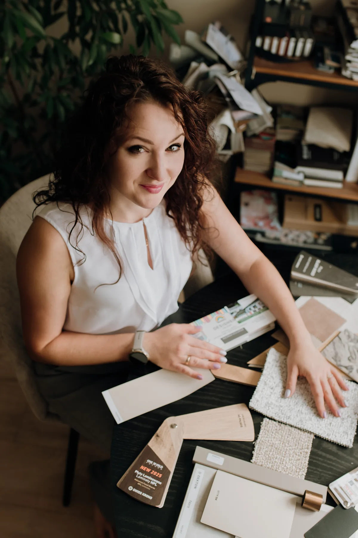 Dominika, projektantka DeCe Wnętrza, przy stole z próbkami materiałów i okładzin